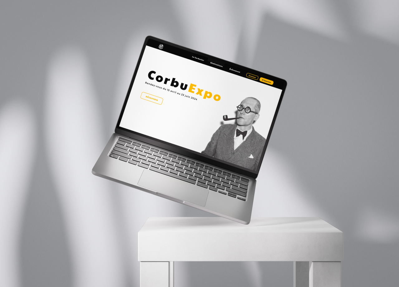 Ordinateur portable affichant le site web de CorbuExpo sur un fond minimaliste.