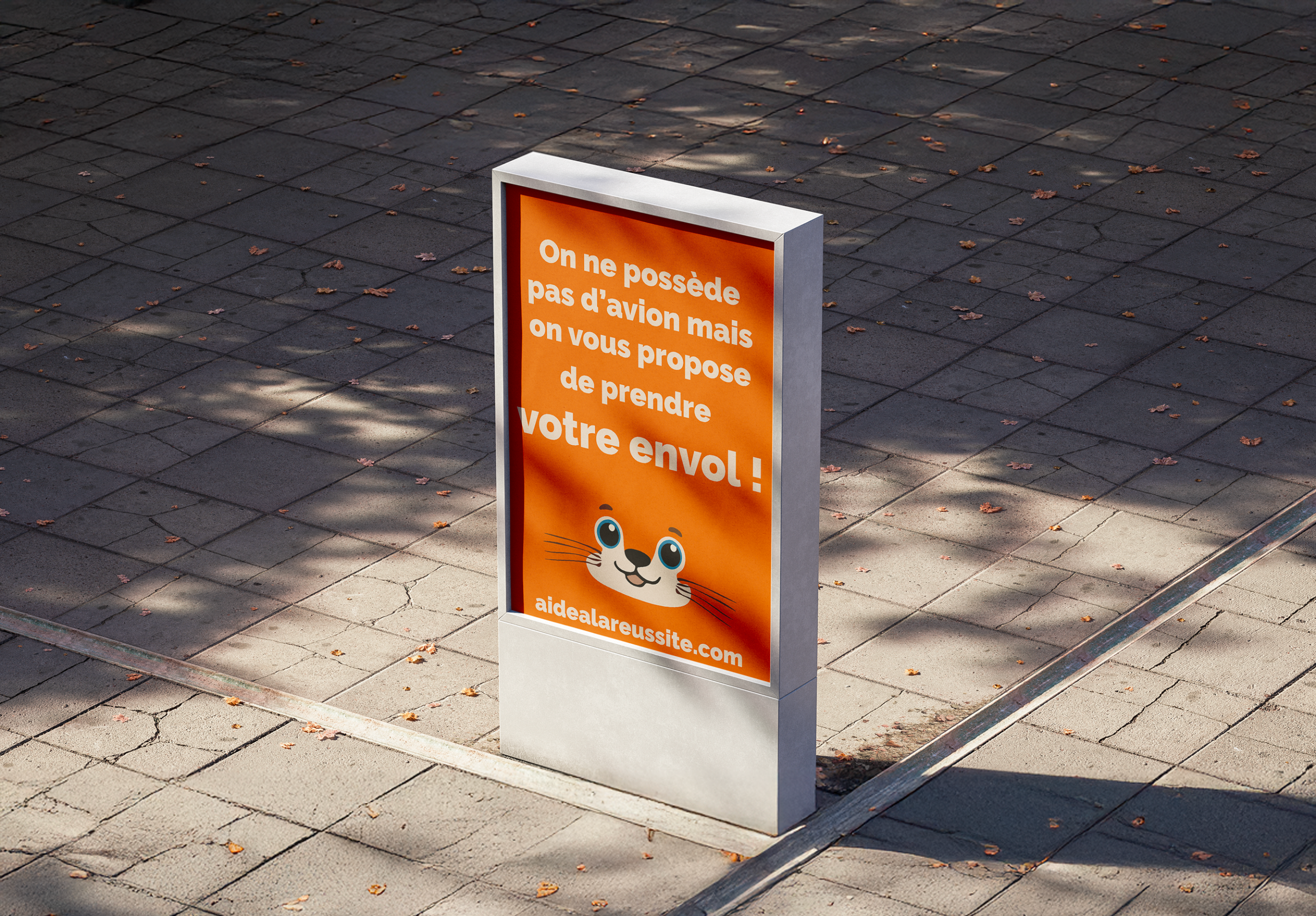 Affiche orange du projet Aide à la réussite installée en extérieur, avec un message motivant invitant à prendre son envol