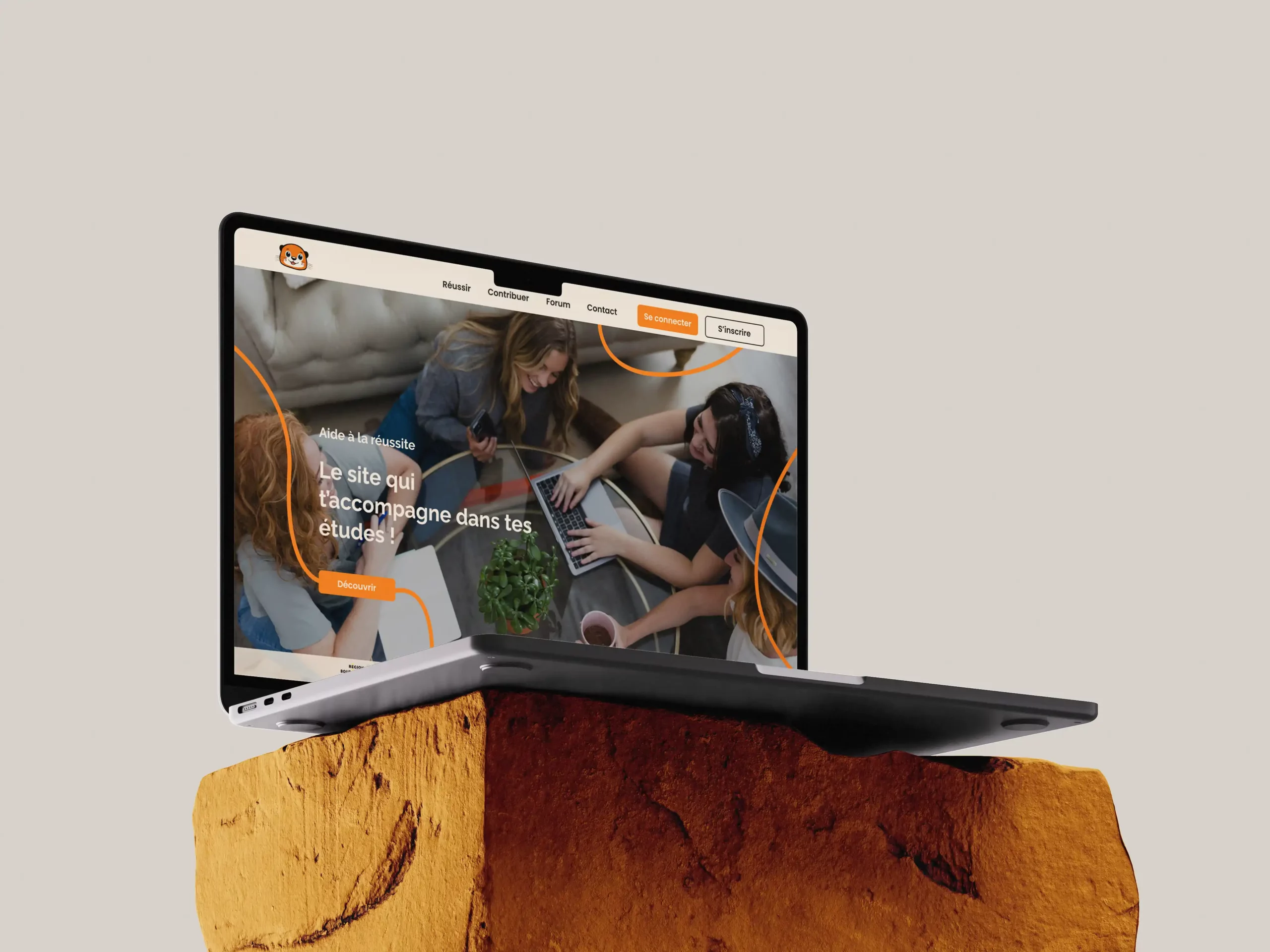 Mockup d’un ordinateur portable affichant la page d’accueil de la refonte du site "Aide à la réussite", avec un design moderne, des couleurs orangées et des éléments graphiques circulaires entourant une image d’étudiants travaillant en groupe.