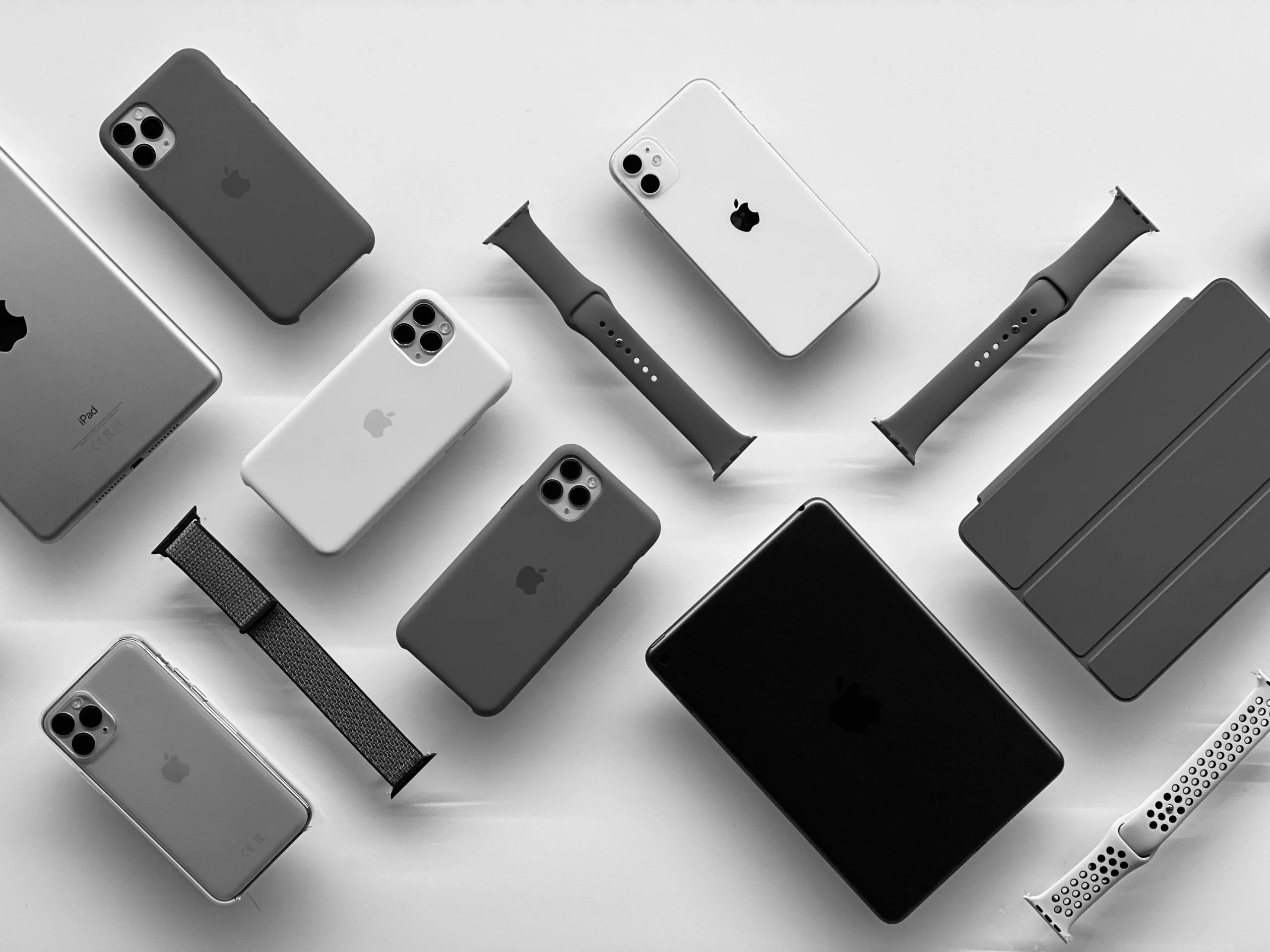 Disposition à plat de produits Apple : iPhone, iPad, Apple Watch et accessoires, en noir et blanc