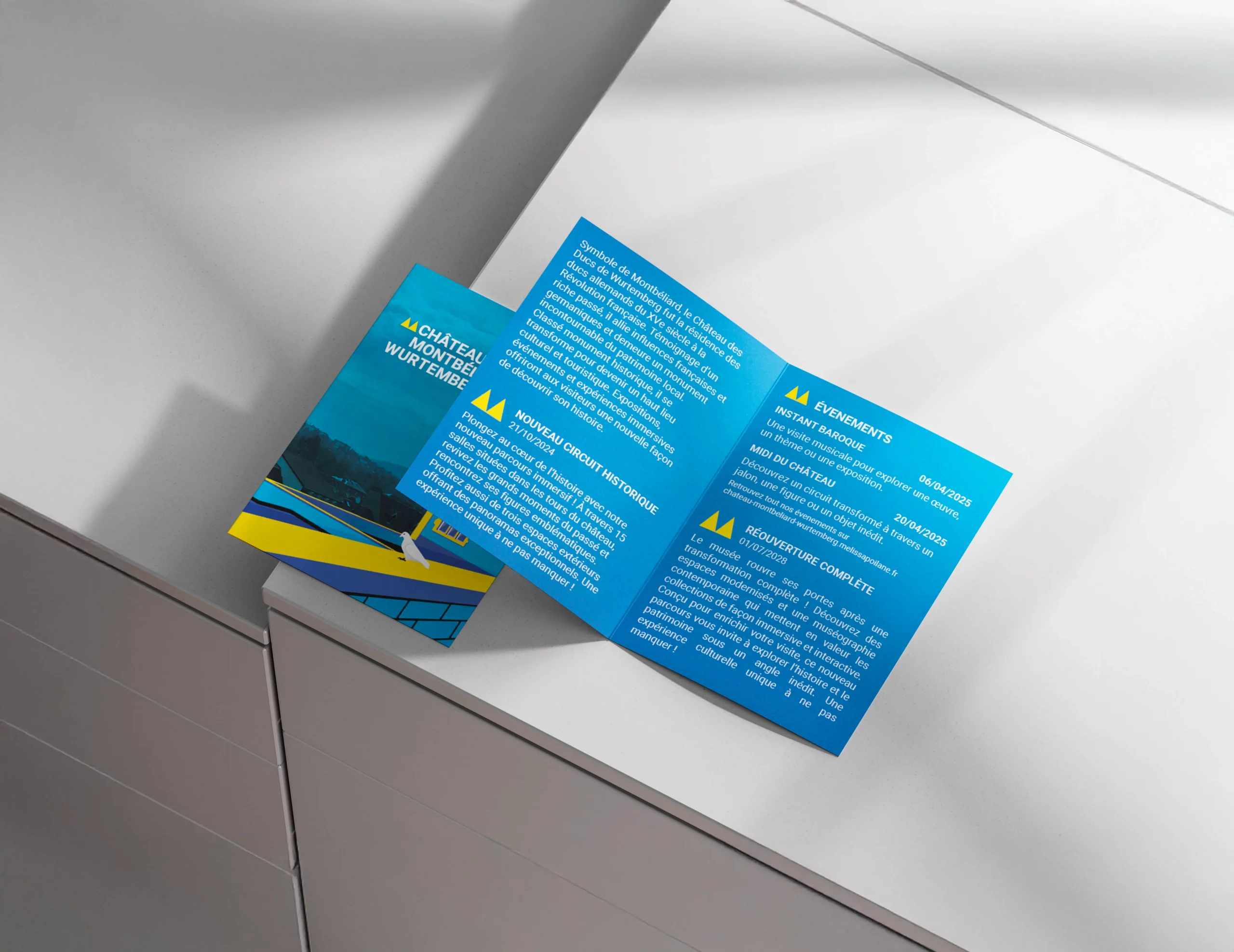 Brochure du château de Montbéliard ouverte, présentant des informations sur le circuit historique et les événements culturels