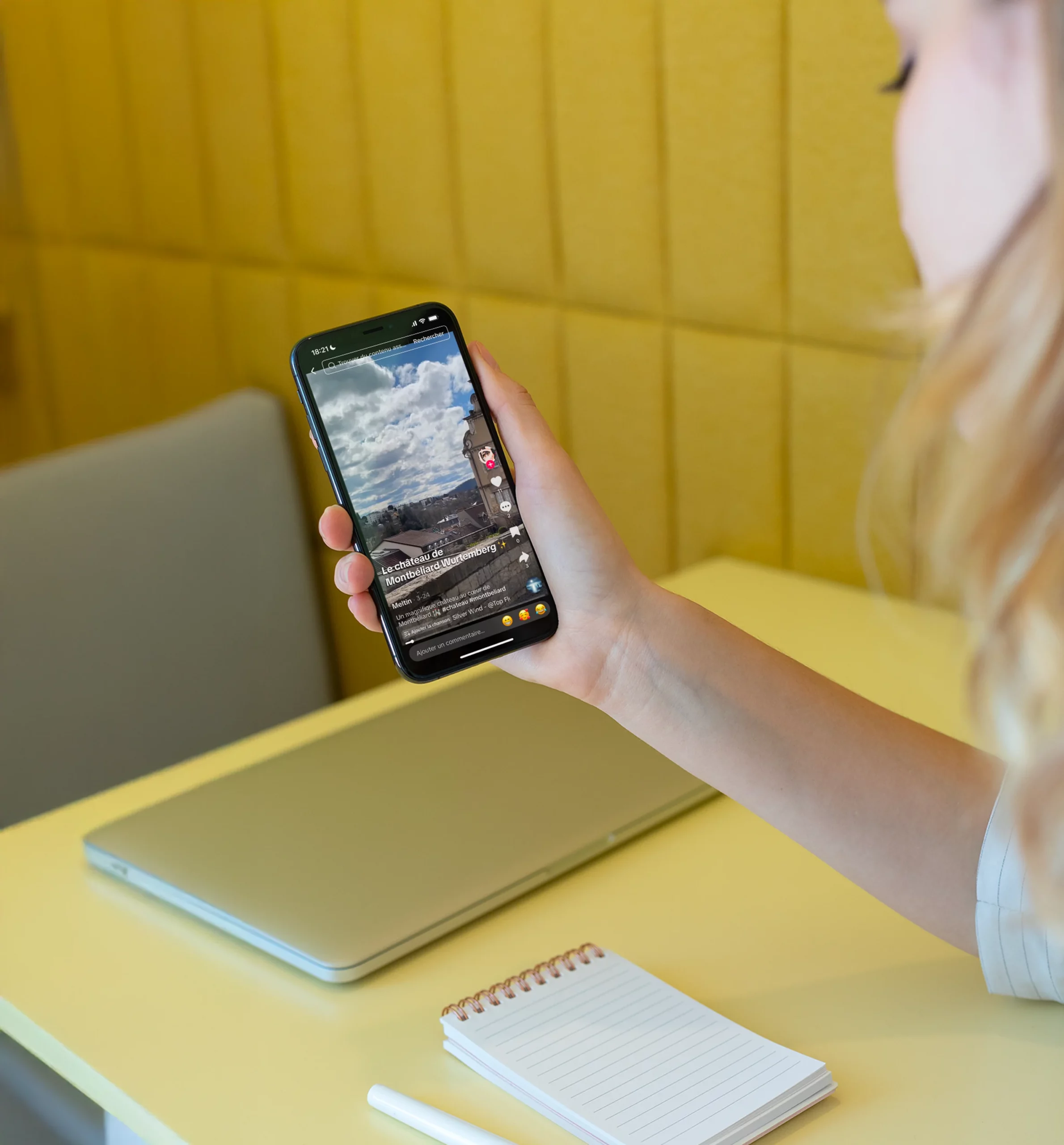Personne tenant un smartphone affichant une vidéo TikTok du château de Montbéliard